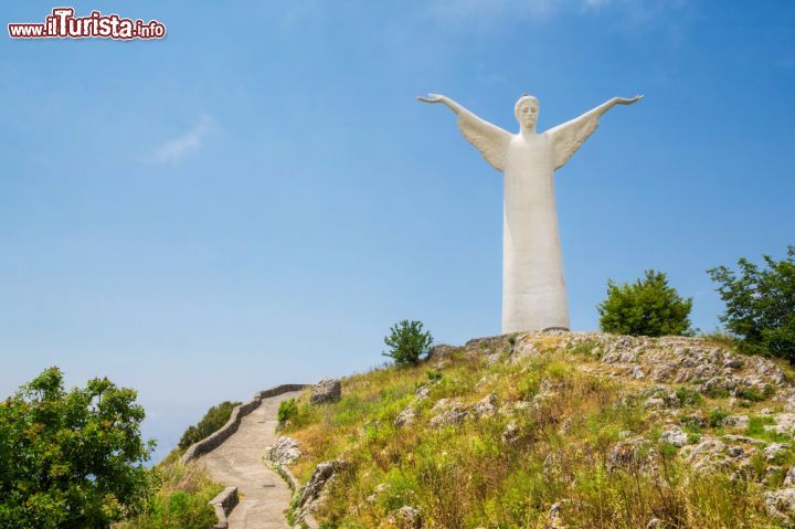 Immagine Statua del Cristo Redentore a Maratea, Basilicata - Questa grande scultura alta 21 metri si trova in cima a monte San Biagio, sopra Maratea. A realizzarla fra il 1963 e il 1965 fu il fiorentino Bruno Innocenti che scelse un particolare impasto di cemento mescolato a scaglie di marmo di Carrara. Il corpo della statua è curvato leggermente in avanti per creare l'illusione ottica, in chi lo osserva da lontano, che il Cristo abbia lo sguardo rivolto verso il mare mentre in realtà la direzione guardata dal volto della statua è quella della basilica di San Biagio © mRGB / Shutterstock.com