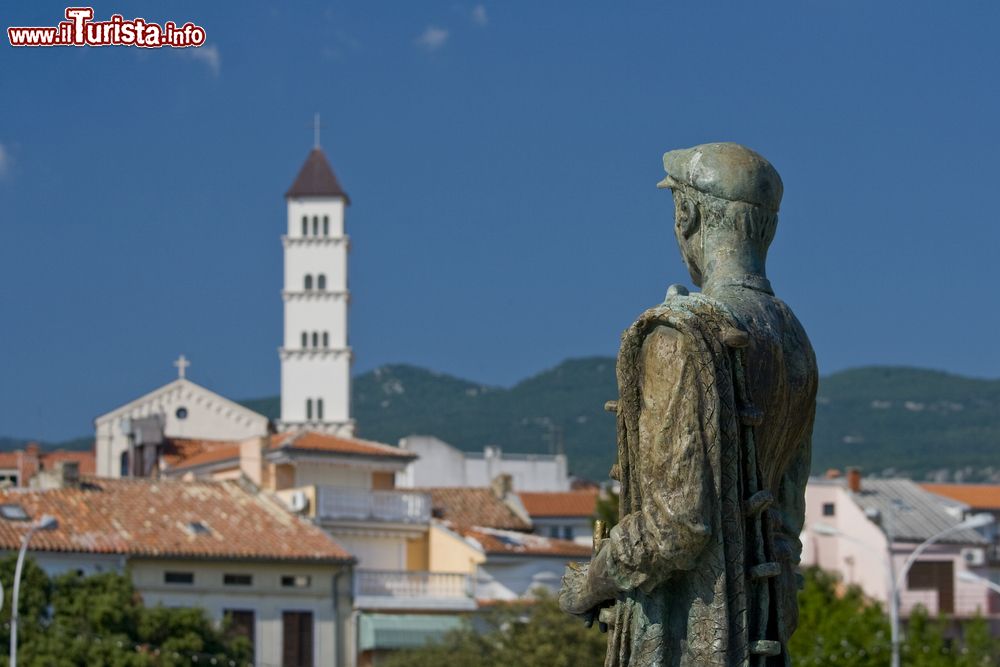 Immagine Statua del pescatore di Crikvenica, Croazia. Sullo sfondo, il campanile della chiesa cittadina.