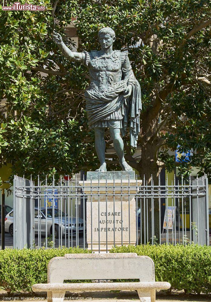 Immagine La statua dell'imperatore Cesare Augusto con Piazza del Popolo sullo sfondo, Brindisi, Puglia. E' la copia in bronzo dell'originale in marmo ritrovato a Roma, nella zona di Prima Porta, durante gli scavi eseguiti nel 1863-64 nella villa di Livia Drusilla Claudia, moglie dell'imperatore - © Alvaro German Vilela / Shutterstock.com