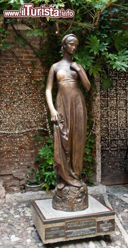 Immagine Statua di Giulietta a Verona - L'opera scolpita nel bronzo raffigura una Giulietta dalle forme slanciate e l'età giovanile, proprio come si presenta nella tragedia Shakesperiana. L'autore di quest'opera è Nereo Costantini che compì la creazione nel 1972. La statua si trova nel cortile e venne posta qui negli anni '70 circa e oggi, moltissimi turisti la possono ammirare (nonché toccare: la leggenda dice che toccando il seno destro della fanciulla, questa porti fortuna) - © Valeri Potapova / Shutterstock.com