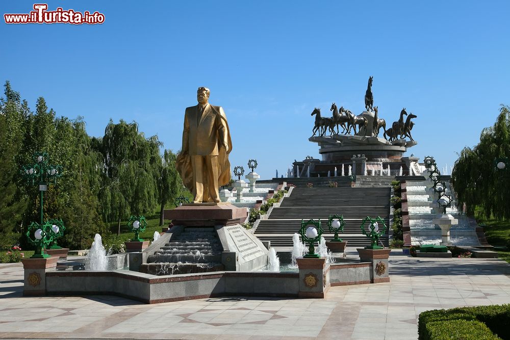Immagine Statua di Niyazov e, sullo sfondo, scultura ai cavalli in un parco di Ashgabat, Turkmenistan. Noto anche come il "Grande Condottiero del Turkmenistan", Niyazov è stato presidente del paese dal 1991 al 2006.