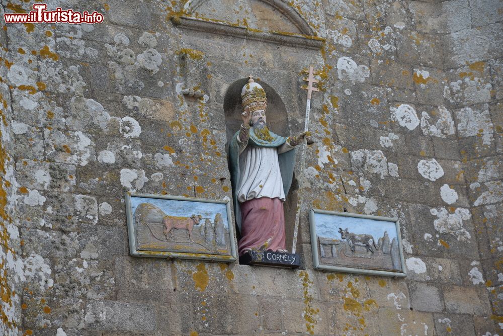 Immagine La statua di San Cornelio in una nicchia dell'omonima chiesa a Carnac, Francia. La scultura del vescovo è adagiata in una nicchia fra due targhe in cui sono raffigurati due buoi.
