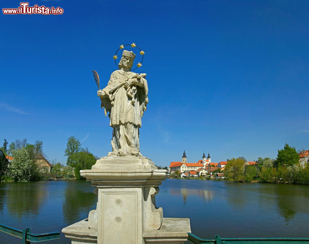 Immagine La statua in marmo di San Giovanni di Nepomuk con il panorama della città di Telc sullo sfondo, Repubblica Ceca. Proclamato santo da Papa Benedetto XIII° nel 1729, Giovanni Nepomuceno è santo patrono di Boemia, dei confessori e di tutte le persone in pericolo di annegamento.
