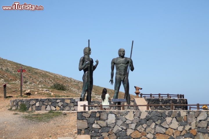 Immagine Le statue di bronzo a Fuerteventura (Spagna) - Come si vede dall'immagine la loro presenza è decisamente mastodontica. Sono alte 4 metri ciascuna e le due statue di bronzo, Ayos e Guize, rappresentano un'attrattiva fortissima non solo per la loro altezza. Entrambi, infatti, rappresentano una porzione di storia importante per Fuerteventura. Sovrano che si è prestato all'alleanza, Ayos, con il re del regno di Maxorata, Guize, per far fronte comune ai conquistadores e scacciarli così dai territori canariani.