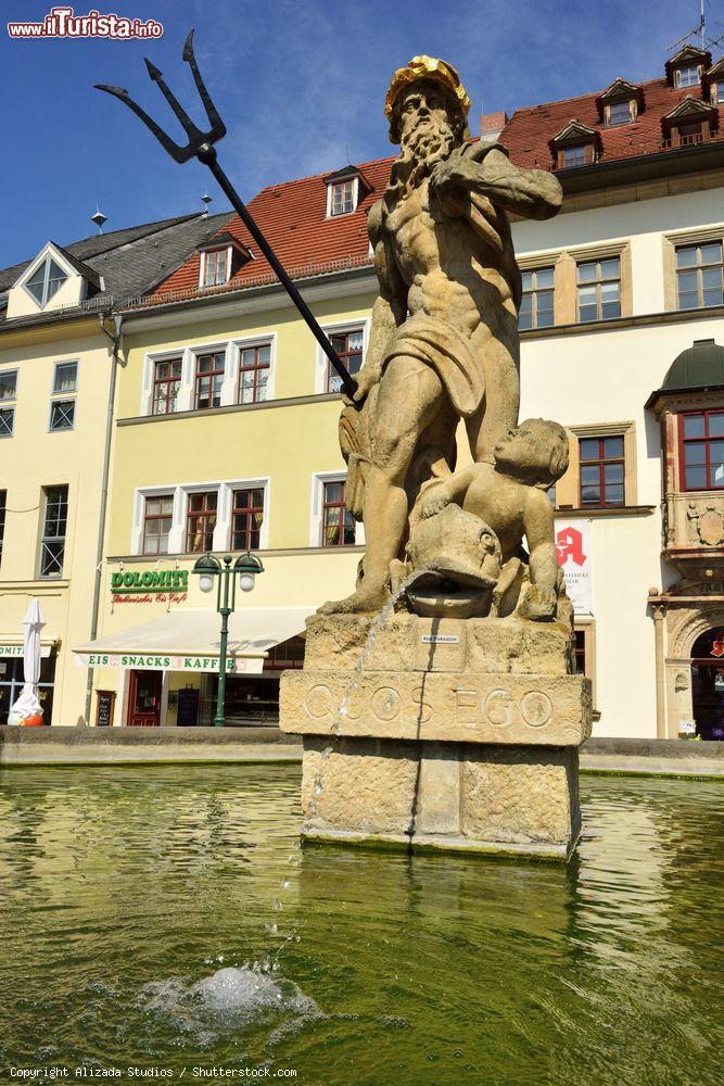 Immagine Storica fontana nella Piazza del Mercato di Weimar, Germania, con la statua di Nettuno. Sullo sfondo, edifici e attività commerciali - © Alizada Studios / Shutterstock.com