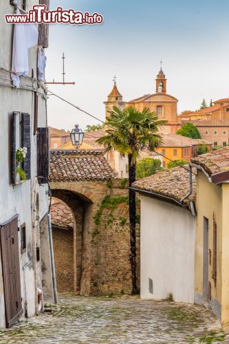 Immagine Strada lastricata a Longiano, Emilia Romagna, Italia. Un suggestivo scorcio fotografico di una stradina con la pavimentazione in ciottoli nel villaggio medievale di Longiano, sulle colline della Romagna. Appesi fuori dalle finestre ad asciugare i vestiti - © GoneWithTheWind / Shutterstock.com