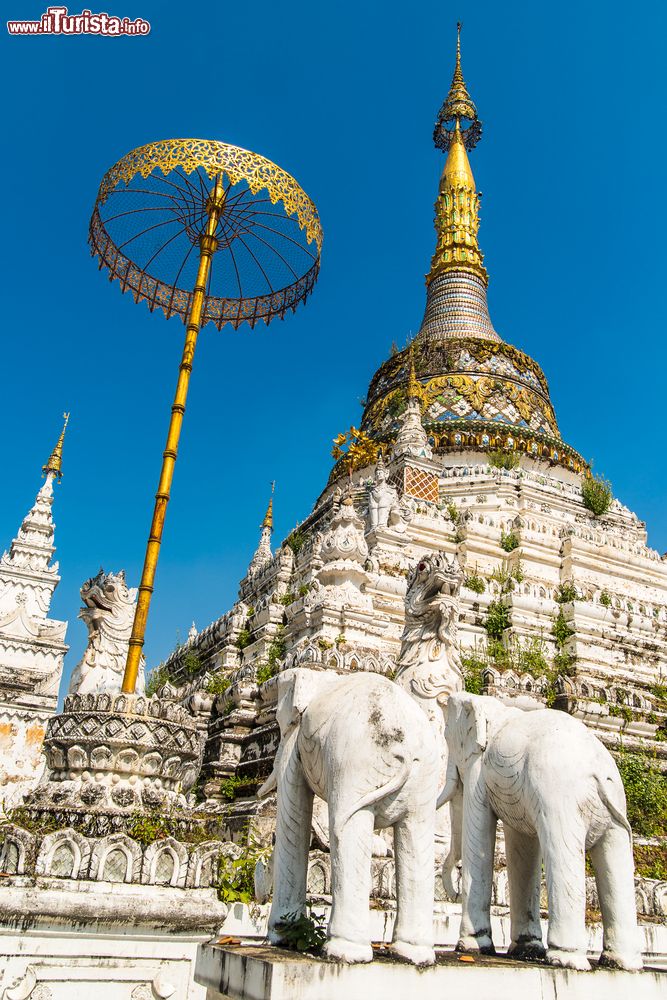 Immagine Stupa al tempio Wat Saen Fang a Chiang Mai, Thailandia. Dettagli architettonici di questo edificio religioso antico finemente decorato. Al suo interno si trova la sala della preghiera a cui si accede dopo aver attraversato una porta intarsiata e decorata con motivi rossi e dorati.