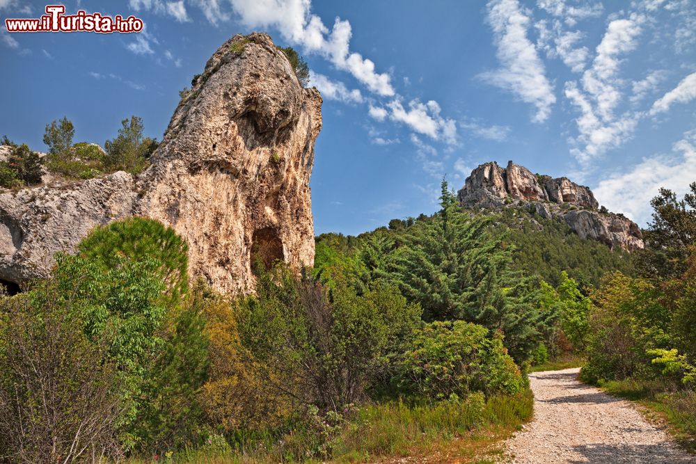 Immagine Un suggestivo panorama montano con formazioni rocciose e vegetazione a Fontaine-de-Vaucluse, Francia.