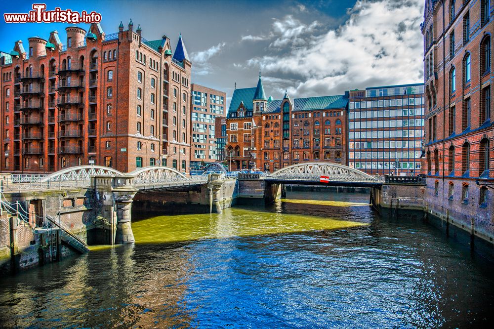 Immagine Un suggestivo scorcio panoramico della città di Amburgo, Germania. Le numerose barche turistiche passano sui corsi d'acqua per un interessante tour di Amburgo.