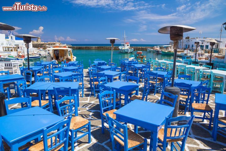 Immagine Taverna nel villaggio di Naoussa, Paros. Ricorda, se mai ce ne fosse bisogno, il colore del cielo e del mare: tavoli e sedie, dalle tonalità azzurre, si affacciano sulle acque del Mar Egeo invitando a gustare i piatti della tradizionale gastronomia locale - © Josef Skacel  / Shutterstock.com