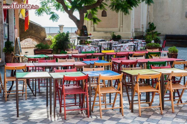 Immagine Tavoli colorati in un ristorante pizzeria della piazza principale di Castelmola, Sicilia. A' Mola, questo il nome in siciliano della cittadina di poco più di mille abitanti, fa parte del circuito dei borghi più belli d'Italia 