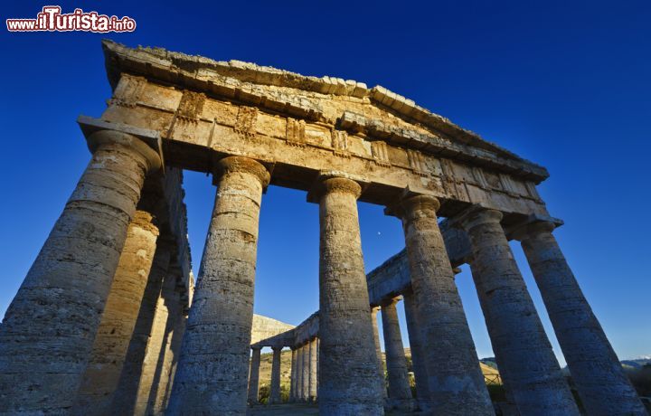 Immagine Tramonto a Segesta, gli ultimi raggi di sole illuminano il frontone del Tempio Greco. L'area archeologica di Segesta si trova nel comune di Calatafimi, in provincia di Trapani, circa a metà strada tra Palermo e Marsala - © Angelo Giampiccolo / Shutterstock.com