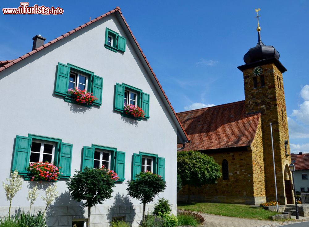 Immagine Tipica casa bavarese con finestre in legno color smeraldo a Frankendorf, nei pressi di Bamberga, Germania.