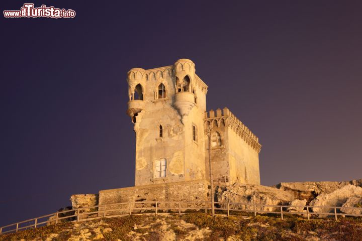 Immagine Antica torre di Tarifa illuminata di notte, Spagna. Un particolare del castello di Santa Catalina che domina dall'alto le acque delle Stretto dove venne costruito nel secondo decennio del XX° secolo. E' uno dei simboli di Tarifa - © Philip Lange / Shutterstock.com