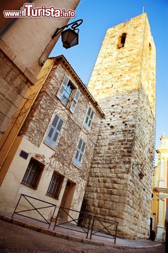 Immagine Torre medievale nel centro di Antibes, Francia - Passeggiando verso il cuore cittadino di questa suggestiva località della Costa Azzurra ci si rende immediatamente conto dell'impronta medievale del paese richiamata da strette viuzze, case alte e strette e dal Chateau Grimaldi che domina il promontorio di Cap d'Antibes. In questa immagine, la torre di costruzione medievale che si innalza nel centro storico di Antibes © Sean Nel / Shutterstock.com