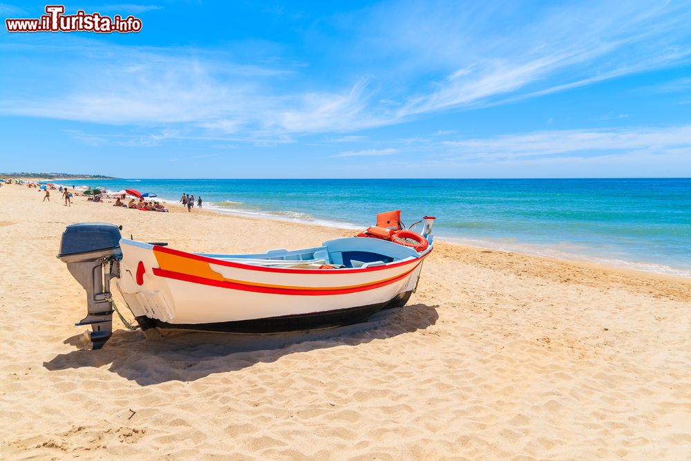 Immagine Una tradizionale barca da pesca colorata ormeggiata sulla spiaggia di sabbia a Armacao de Pera nella regione dell'Algarve, Portogallo.