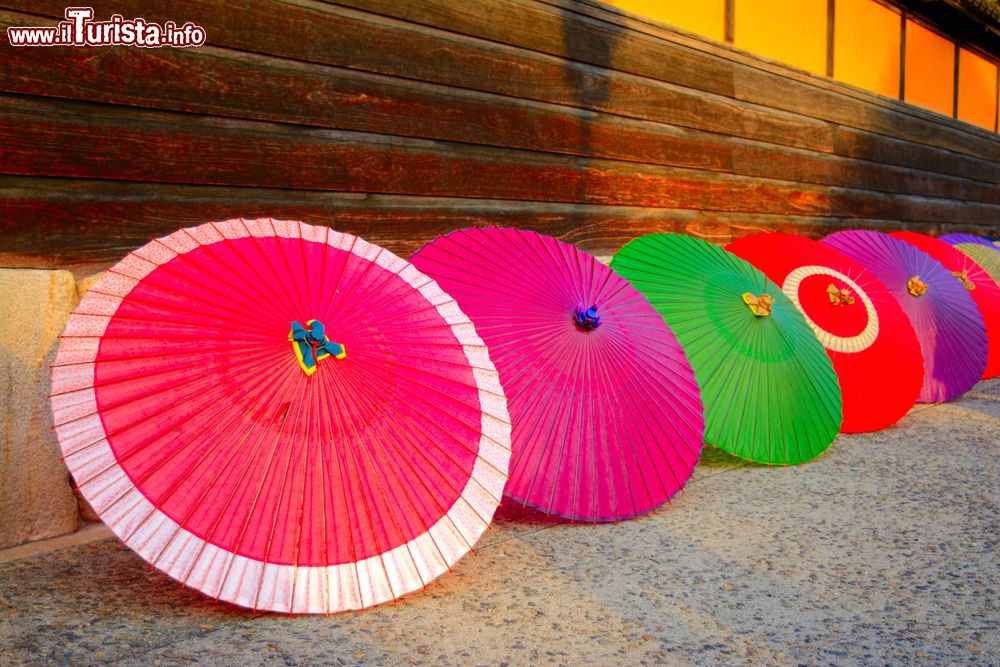 Immagine Tradizionali ombrelli giapponesi colorati a Kurashiki,Okayama, Giappone. Risalente al periodo Edo dell'epoca samurai, questo villaggio si trova nell'isola di Honshu.