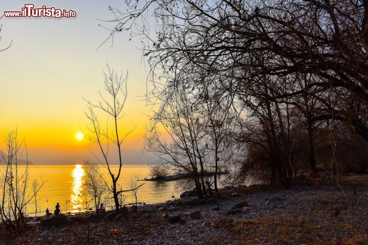 Immagine Tramonto a Ascona, Svizzera. Gli splendidi colori del calar del sole sul lago Maggiore fotografato da Ascona. Situata in una bella e soleggiata baia del bacino, questa cittadina è una delle mete turistiche più amate ed esclusive della Svizzera. Qui si trova infatti tutto ciò che si può desiderare per trascorrere una vacanza all'insegna del relax: un grande lido, negozi e boutique per lo shopping, paesaggi naturali per passeggiate in assoluta tranquillità - © Rigoni Barbara / Shutterstock.com