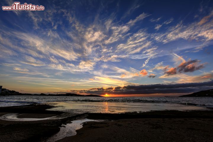 Immagine Tramonto con sfumature color arancione nel cielo nuvoloso alla baia di Finikas, isola di Syros, Grecia - © Lemonakis Antonis / Shutterstock.com