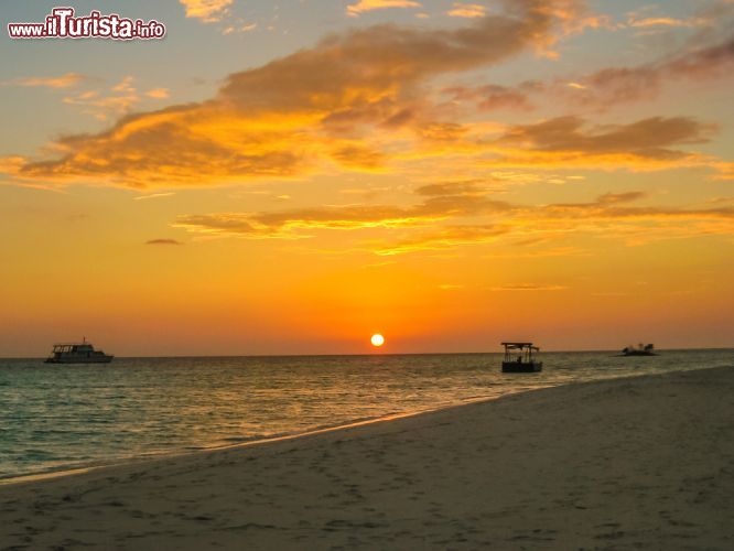 Immagine Tramonto dalla spiaggia di un'isola dell'Atollo di Malé Nord, Maldive. Le imbarcazioni fanno la spola per portare i turisti dall'aeroporto di Malé ai resort sulle isole - foto © Shutterstock.com