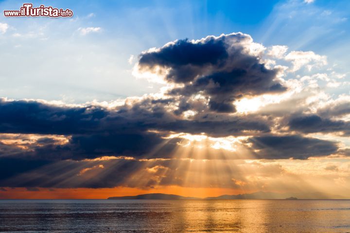 Immagine Un suggestivo tramonto con i raggi del sole che si insinuano tra le nuvole sul Mar Tirreno presso la città di Follonica, in provincia di Grosseto - foto © Shutterstock