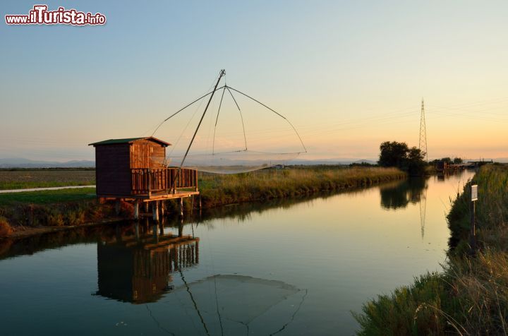 Immagine I padelloni, le capanne per la pesca, fotografate al tramonto in una canale che alimenta le saline di Cervia, in Emilia-Romagna - © lafoto / Shutterstock.com