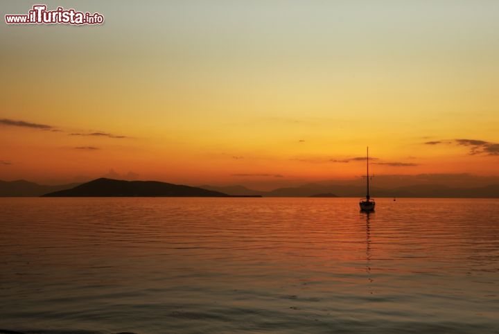 Immagine Tramonto sull'isola di Angistri e sulle montagne del Peloponneso, Grecia. Uno yacht in mezzo al mare visto da Egina, isola greca situata a 50 km da Atene - © Paul Cowan / Shutterstock.com