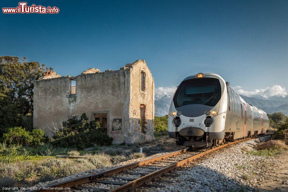 Immagine Treno in transito davanti a un antico edificio in pietra nei pressi della stazione di Lumio, Corsica - © Jon Ingall / Shutterstock.com