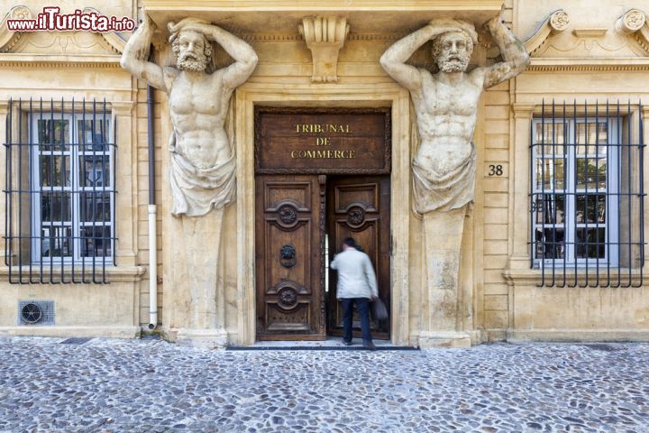 Immagine Il Tribunal de Commerce sul Cours Mirabeau a Aix-en-Provence, Francia - Si trova al civico numero 38 di Cours Mirabeau l'imponente palazzo che ospita il tribunale del commercio di Aix en Provence. Particolarmente suggestivo è l'ingresso principale dell'edificio impreziosito da due grandi figure maschili posizionate ai lati del portone in legno © Aurelien Laforet / Shutterstock.com