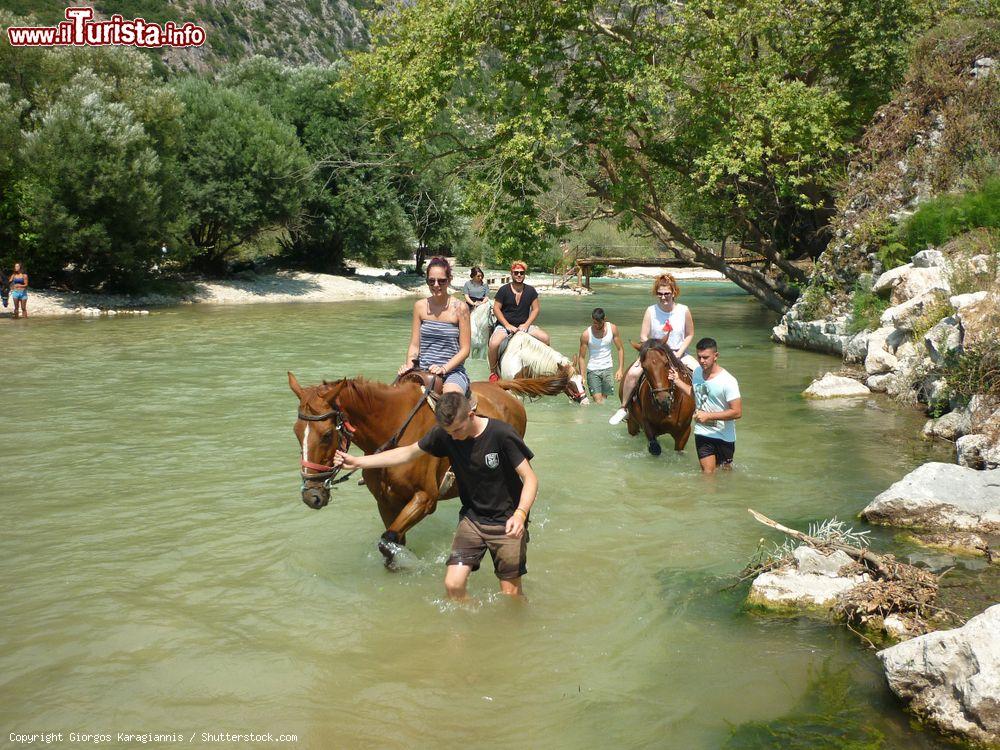 Immagine Turisti a cavallo lungo il fiume Acheronte nei pressi di Gliki, Preveza, Grecia. L'Acheronte era noto in antichità come il fiume della sventura; associato al mondo degli inferi, si pensava fosse un ramo del fiume Stige che scorre sottoterra e attraverso cui Caronte traghettava nell'Ade le anime dei morti - © Giorgos Karagiannis / Shutterstock.com