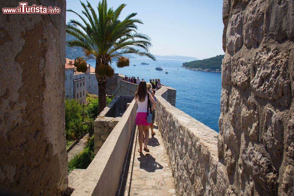 Immagine Turisti a passeggio lungo i camminamenti delle fortificazioni di Dubrovnik, Croazia.