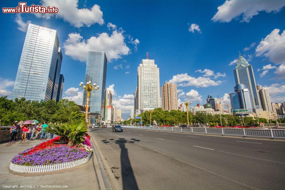 Immagine Turisti a passeggio lungo un viale di Urumqi, Cina - © smiling_z / Shutterstock.com