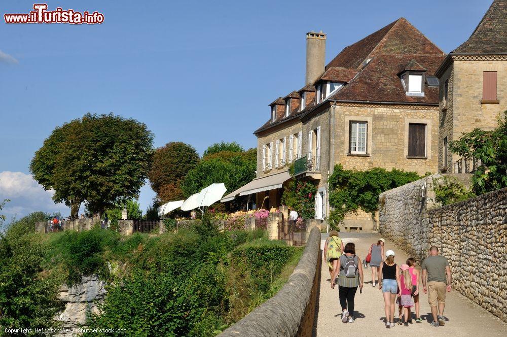 Immagine Turisti a passeggio nella via pedonale del centro di Domme, Dordogna, Francia - © Heliosphile / Shutterstock.com