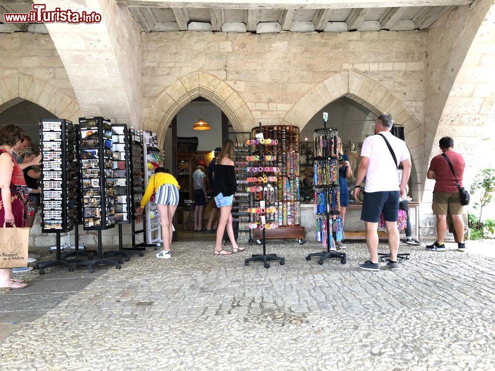 Immagine Turisti acquistano cartoline e braccialetti in un negozio di Monpazer, Dordogna, Francia - © Cmspic / Shutterstock.com