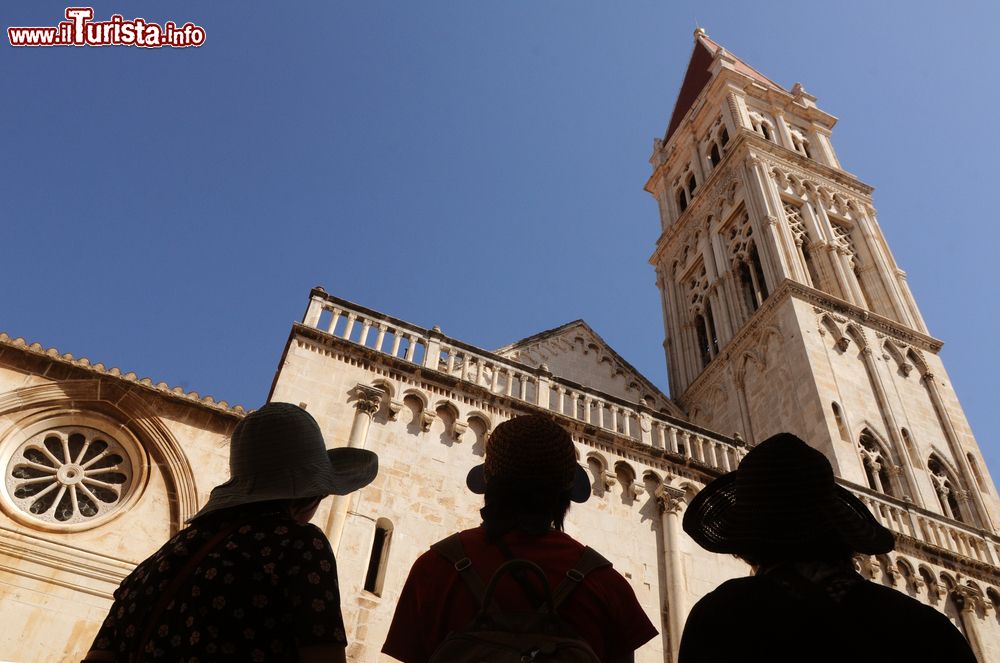 Immagine Turisti ammirano la chiesa di San Sebastiano in piazza Giovanni Paolo II° a Trogir, Croazia. Costruito nel 1476, questo edificio non viene più utilizzato per cerimonie religiose: al suo interno sonoe sposte foto della guerra in croazia degli anni Novanta.