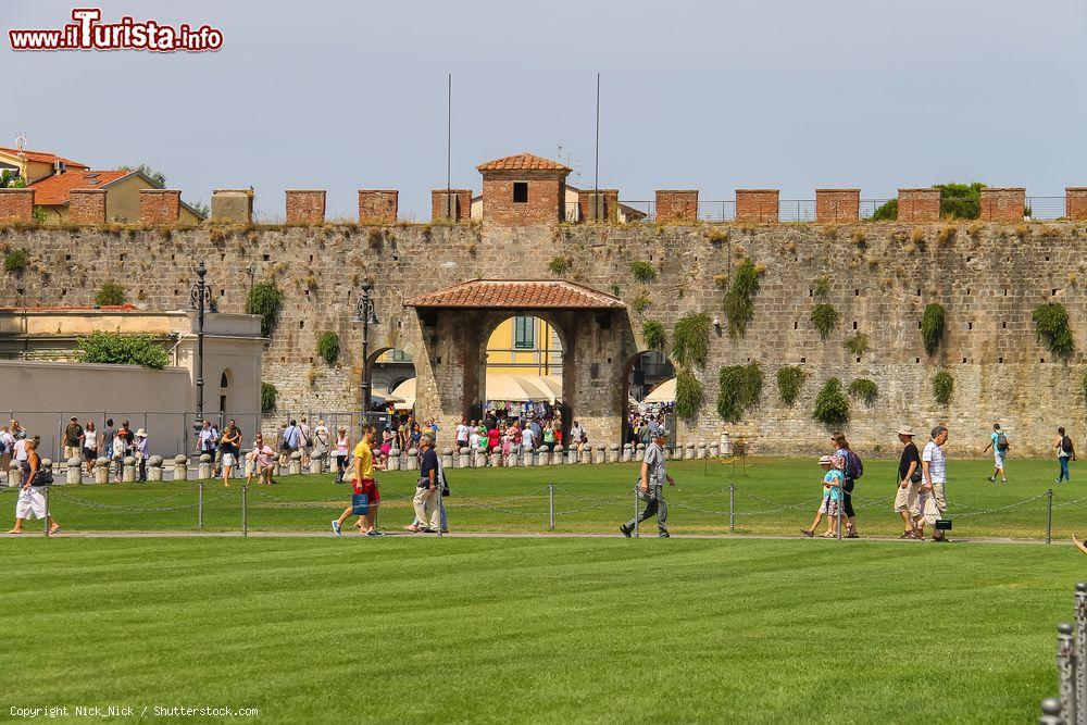 Immagine Turisti in Piazza del Duomo a Pisa, Toscana. Conosciuta anche come Piazza dei Miracoli, è il centro artistico e culturale più importante della cittadina toscana. Ospita alcuni dei monumenti principali di Pisa fra cui la cattedrale, il battistero, il camposanto e il campanile - © Nick_Nick / Shutterstock.com