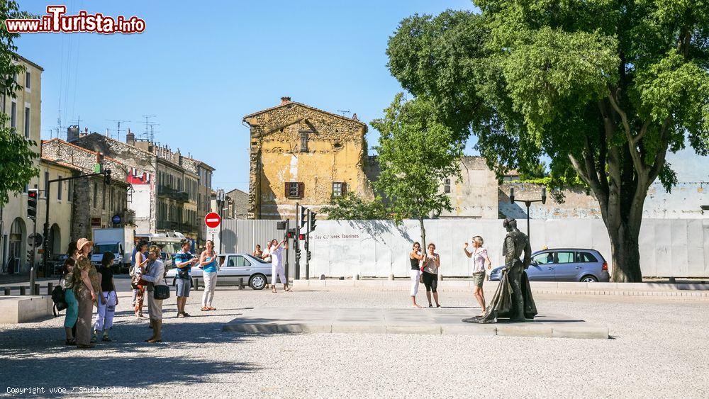 Immagine Turisti in posa vicino alla statua di Christian Montcouquiol (Nimeno II°, torero francese) in Place des Arenes a Nimes (Francia) - © vvoe / Shutterstock.com