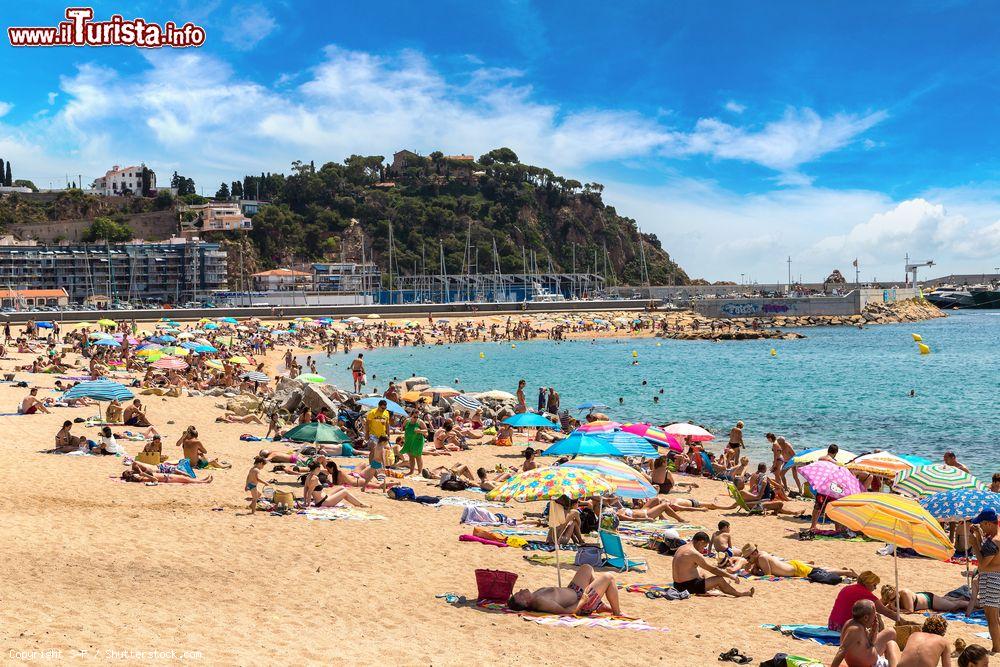Immagine Turisti in relax sulla spiaggia di Blanes, Costa Brava, Spagna. Lungo la costa di questa località si alternano scogliere e insenature tranquille - © S-F / Shutterstock.com