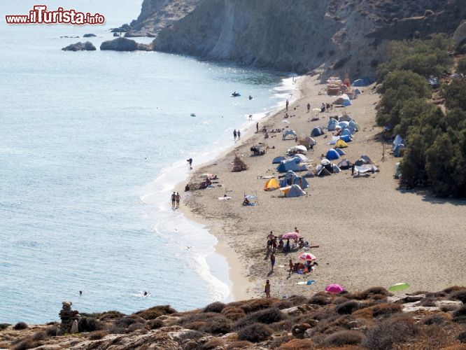 Immagine Turisti in spiaggia sul litorale di Anafi, Grecia. Alcune calette sabbiose possono essere raggiunte comodamente dalla strada mentre per ammirare quelle più isolate bisogna avventurarsi su sentieri fra rocce calcaree - © Kostas Koutsaftikis / Shutterstock.com