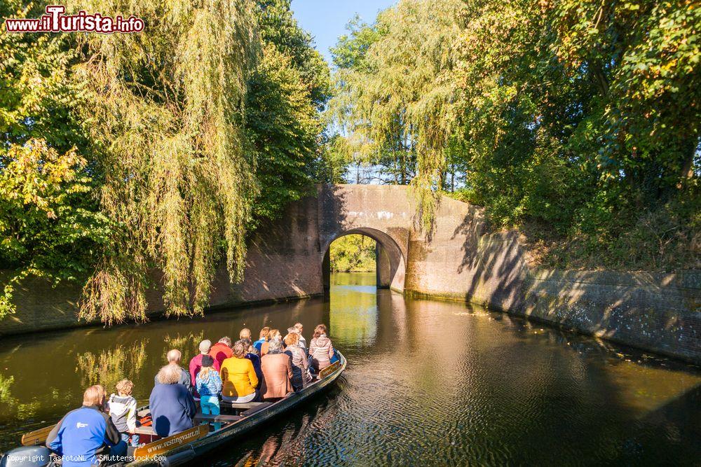 Immagine Turisti su una barca in un canale della cittadina di Naarden, Paesi Bassi. Un suggestivo scorcio autunnale del paesaggio naturale in cui si trova questa località le cui tracce risalgono all'anno mille - © TasfotoNL / Shutterstock.com