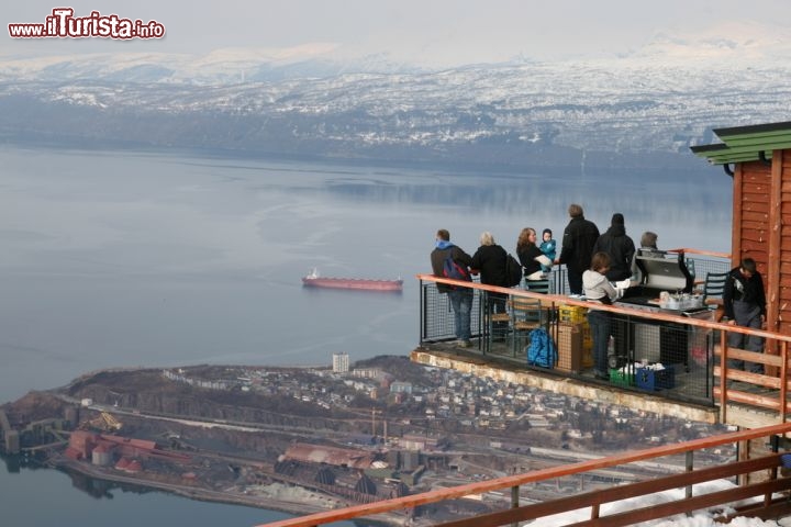 Immagine Turisti sul monte Narviksfjellet a Narvik, Norvegia - Uno dei panorami più incantevoli sulla città di Narvik si può ammirare dalla cima del monte Narviksfjellet, conosciuto dagli apapssionati di sci per le sue piste. In questa immagine un gruppo di turisti osserva dall'alto fiordo e montagne imbiancate dalla neve © steelneck / Shutterstock.com