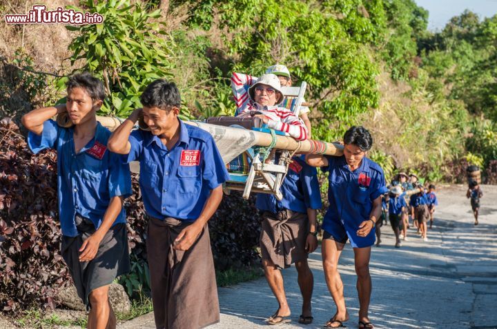 Immagine Turisti trasportati da uomini birmani alla pagoda di Kyaiktiyo, Myanmar. Questo luogo di pellegrinaggio si trova a 1100 metri di altezza sul livello del mare - © SIHASAKPRACHUM / Shutterstock.com