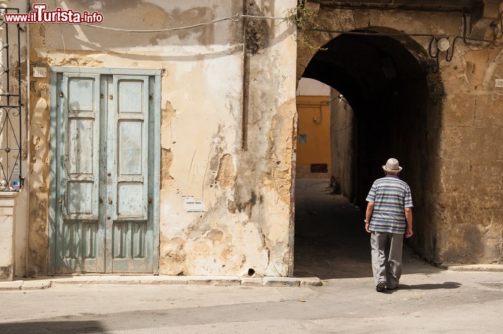 Immagine Un anziano signore cammina lungo un vicolo del centro di Marsala, Sicilia.