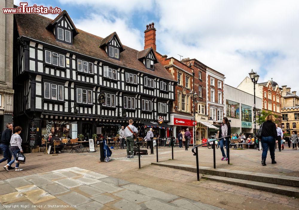 Immagine Un artista di strada di fronte a edifici a graticcio nel centro di Lincoln, Inghilterra - © Nigel Jarvis / Shutterstock.com