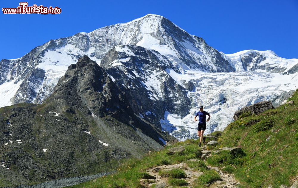 Immagine Un atleta percorre correndo gli sterrati fra le montagne di Arolla, Svizzera, in una giornata di sole.