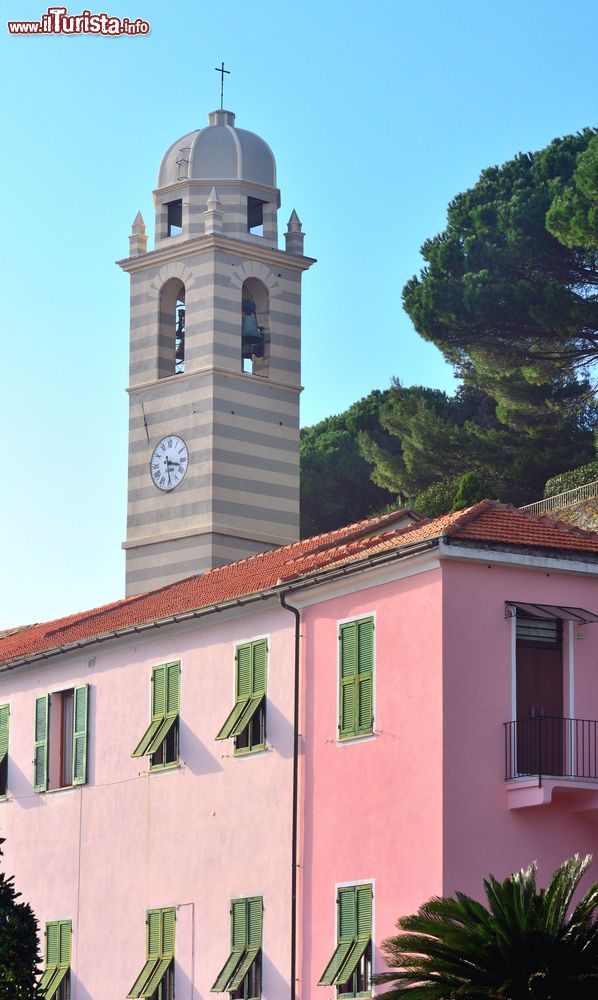 Immagine Un campanile di Celle Ligure, Liguria, dietro a un edificio tinteggiato nelle sfumature del rosa.