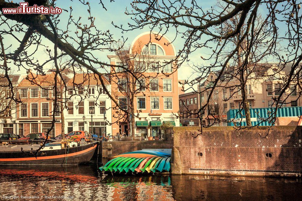 Immagine Un canale a L'Aia con barche e canoe ormeggiate (Olanda). Sullo sfondo, le tipiche abitazioni della cittadina olandese - © Radiokafka / Shutterstock.com