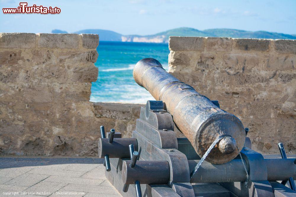 Immagine Un cannone sui bastioni della città di Alghero in Sardegna. Sullo sfondo la costa di Capo Caccia - © Gabriele Maltinti / Shutterstock.com