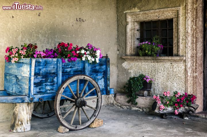 Immagine Un carretto in legno abbellito con fiori nel centro storico di Tenno, Trentino Alto Adige - © Ardenvis / Shutterstock.com