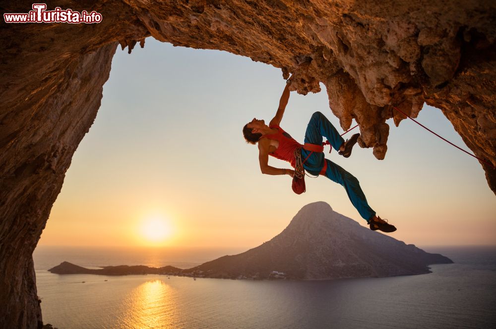 Immagine Un climber scala la parete di una grotta sull'isola di Kalymnos, Grecia, al tramonto.